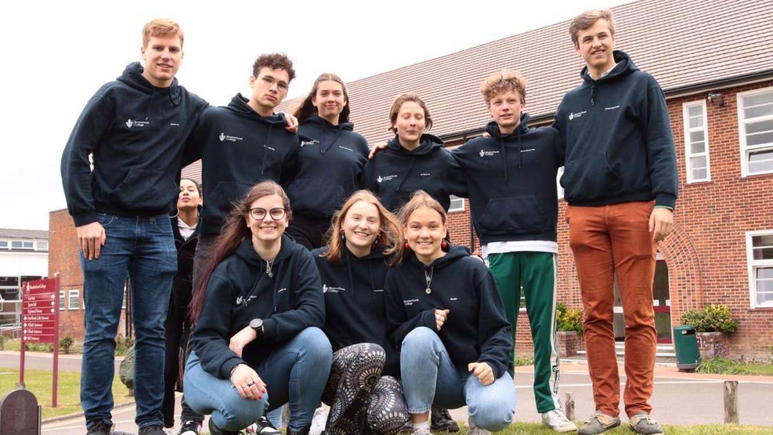 Grupo de estudantes à frente da escola